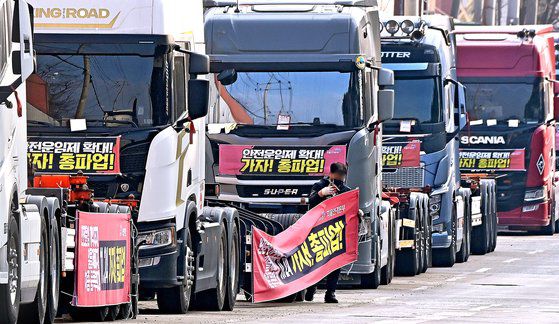 화물연대가 총파업을 철회한 지난 9일 오후 경기도 의왕시 내륙컨테이너기지(ICD)앞 도로에 주차된 화물차에서 한 조합원이 현수막을 철거하고 있다. 뉴시스
