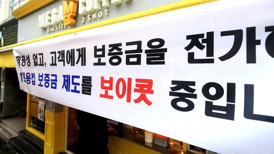 전국에서 처음으로 제주도 내 일부 프랜차이즈 매장을 대상으로 일회용컵 보증금제도가 실시된 2일 오전 제주시 연동의 한 프랜차이즈 카페에 보증금제도를 보이콧한다는 현수막이 걸려 있다. [연합뉴스]