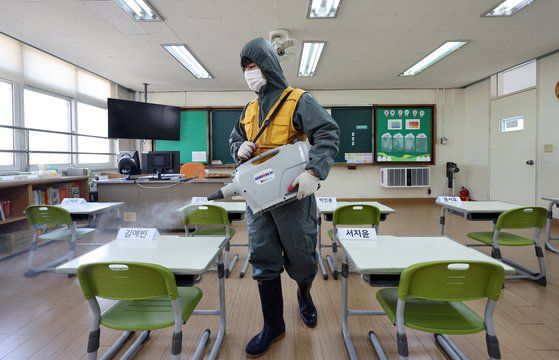 개학을 사흘 앞둔 지난달 27일 충북 청주시 상당구의 한 초등학교에서 소독전문업체 직원이 코로나19 감염 예방을 위해 소독약을 뿌리고 있다. 연합뉴스
