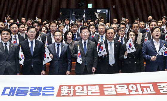 이재명 더불어민주당 대표와 의원들이 16일 오후 국회 예결위 회의장에서 의원총회를 열고 윤석열 정부의 대일 굴욕외교를 규탄하는 태극기 퍼포먼스를 하고 있다. 김성룡 기자