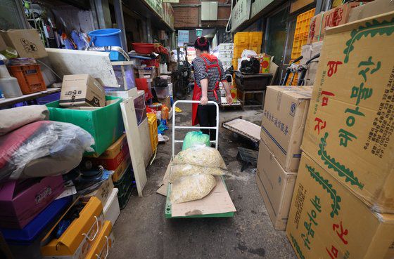 코로나19 이후 자영업자들의 대출(사업자대출+가계대출) 규모가 1000조원을 넘어선 것으로 집계됐다. 또 이들 10명 가운데 6명은 3개(기관·상품) 이상의 대출로 자금을 끌어 써 금리 인상기에 가장 위험한 '다중채무자'인 것으로 나타났다.   3일 서울의 한 시장에서 상인이 식자재를 옮기고 있다. 연합뉴스