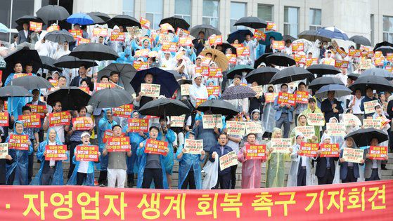한국외식업중앙회 소속 회원들이 지난달 20일 서울 여의도 국회 본청 앞에서 열린 자영업자·소상공인 생계 회복 촉구 기자회견에서 최저임금 인상 반대 등 구호를 외치고 있다. 뉴스1