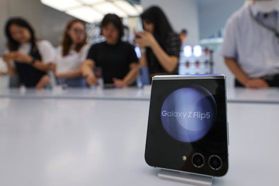 27일 서울 서초구 삼성 강남을 찾은 시민들이 갤럭시 Z플립5과 Z폴드5 등 신제품을 살피고 있다.   삼성전자는 전날 밤 코엑스에서 '갤럭시 언팩'을 열고 갤럭시 Z플립5·폴드5, 태블릿PC 갤럭시 탭 S9, 스마트워치 갤럭시워치6 등 신제품을 공개했다. 연합뉴스