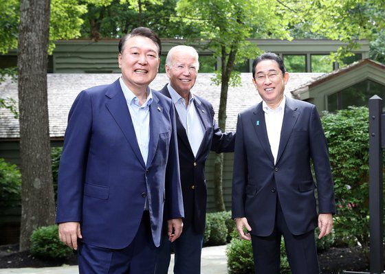 윤석열 대통령이 지난 8월 미국 대통령 별장 캠프 데이비드에서 한·미·일 정상회의에 앞서 조 바이든 미국 대통령, 기시다 후미오 일본 총리와 만나 기념촬영하고 있다. [뉴시스]