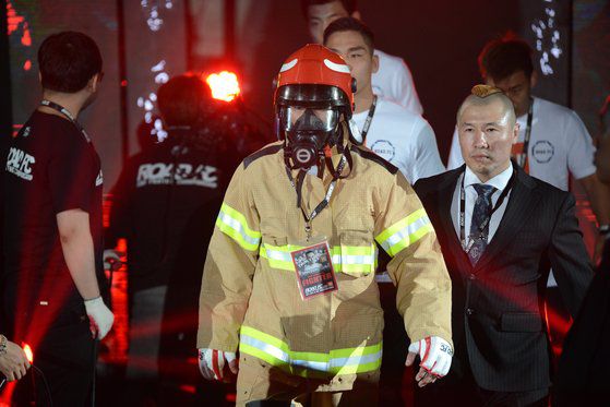 방화복에 헬멧을 쓰고 경기장에 입장하는 신동국(가운데). 사진 로드FC