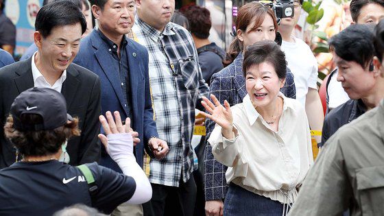 박근혜 전 대통령이 25일 오전 대구 달성군 현풍시장을 찾아 먹거리를 사고 있다. 뉴스1