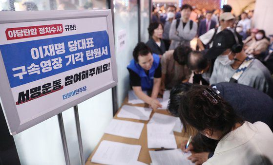 지난 24일 오후 서울 강서구 양천구 진교훈 더불어민주당 강서구청장 후보자 선거사무소에서 민주당 지지자들이 이재명 대표 구속영장 기각 탄원서에 서명을 하고 있다. 뉴스1