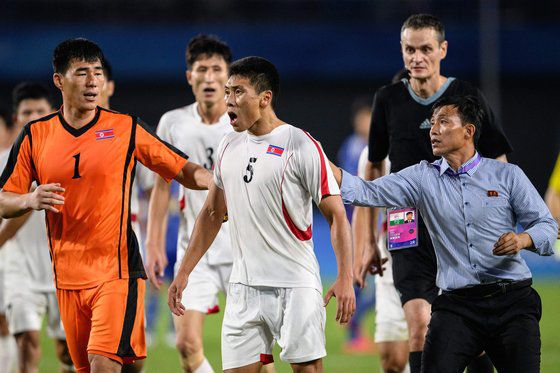 1일 열린 2022 항저우 아시안게임 남자 축구 8강전에서 북한 대표팀 김경석 선수가 심판에 항의하자 동료 선수와 스태프들이 말리고 있는 모습. AFP=연합뉴스