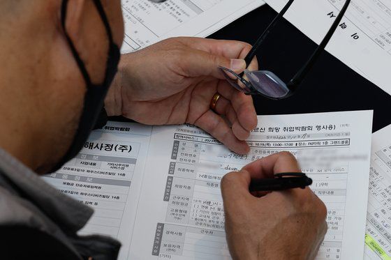 지난19일 서울 영등포구 FKI타워에서 열린 2023 중장년·어르신 취업박람회에서 참가자가 구직신청서를 쓰고 있다. 뉴스1