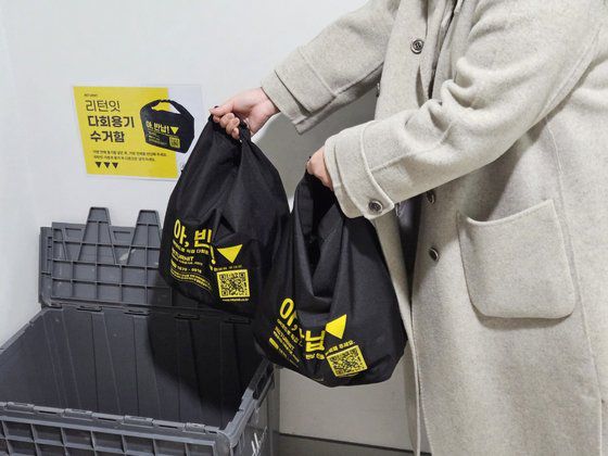 13일 김 주무관이 식사를 마친 뒤 다회용 용기가 담긴 검은색 가방을 경기도청 19층 엘리베이터 옆에 설치된 수거함에 넣고 있다. 수거함에 들어간 가방은 다음날 아침 업체가 수거해간다. 심석용 기자