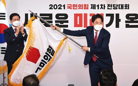 2021년 6월 11일 이준석 국민의힘 전 대표가 서울 영등포구 여의도동 국민의힘 당사에서 열린 전당대회에서 당기를 흔들고 있다. 당시 이 전 대표는 통상 전당대회 출마 비용의 10분의 1 수준인 3000만원 미만으로 대표 선거에 출마해 당선되며 화제를 낳았다. 오종택 기자