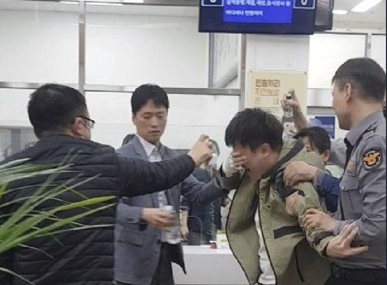 지난해 4월 26일 부산시청 2층 행복민원실에서 난동을 부리던 A씨가 얼굴에 호신용 스프레이를 맞고 괴로워하고 있다. 이 상황은 민원인 폭력행위 대응 모의 훈련에서 연출됐다. 사진 부산시