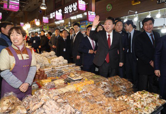 윤석열 대통령이 21일 울산전시컨벤션센터에서 열린 민생토론회를 마치고 신정상가시장을 방문해 상인들에게 인사하고 있다. [사진 대통령실사진기자단]