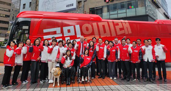 인요한 국민의미래 선거대책위원장을 비롯한 비례대표 후보들이 지난달 26일 서울 여의도 당사에서 열린 선거대책위원회의를 마치고 국민의미래 버스에서 기념촬영을 하고 있다. 뉴스1
