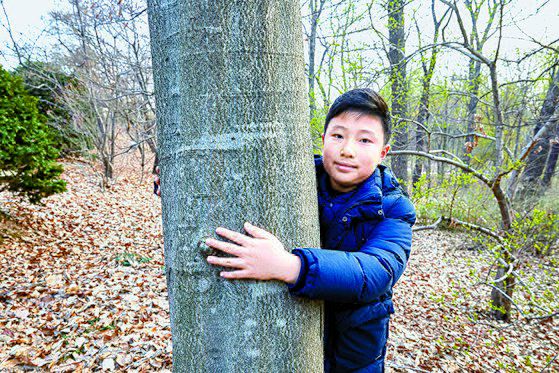 너도밤나무의 둘레를 재듯 끌어안은 전상윤 학생기자. 옆에는 밤나무와 나도밤나무가 함께 있다.