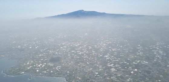 황사 영향으로 제주지역 미세먼지 농도가 연이틀 '매우 나쁨' 수준을 보인 18일 제주도 상공에서 바라본 제주 도심이 뿌연 먼지로 갇혀 있다. 뉴시스