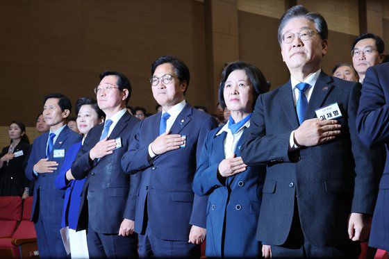 더불어민주당 이재명 대표와 국회의장단 후보들이 16일 오전 국회 의원회관에서 열린 제22대 전반기 국회의장단 후보 선출을 위한 당선자 총회에서 국기에 경례하고 있다. 왼쪽부터 이학영·남인순·민홍기 국회부의장 후보, 우원식·추미애 국회의장 후보, 이재명 대표. 연합뉴스