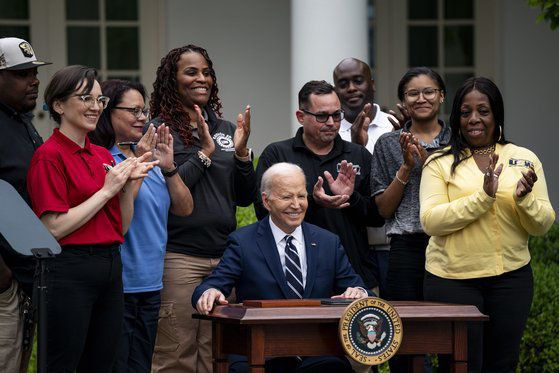 조 바이든 미국 대통령이 14일(현지시간) 백악관 로즈가든에서 철강노조(USW) 등 연관 산업 노조원들이 지켜보는 가운데 중국산 전기차, 배터리, 범용 반도체 등에 대한 관세를 최대 4배 인상하는 내용을 담은 문서에 서명한 뒤 미소를 짓고 있다. [UPI=연합뉴스]
