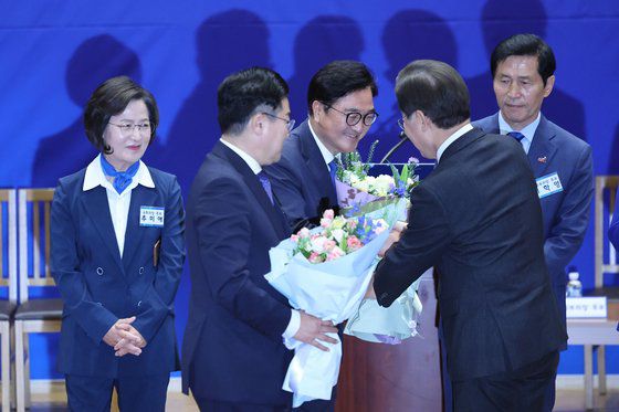 16일 서울 여의도 국회 의원회관에서 열린 더불어민주당 당선자 총회에서 우원식 의원(왼쪽 셋째)이 추미애 당선인(왼쪽)을 누르고 22대 전반기 국회의장 후보로 선출됐다. 추미애 대세론을 뒤집은 이변이다. 결과 발표 뒤 이재명 대표(오른쪽)가 우 의원에게 꽃다발을 건네고 있다. [뉴시스]