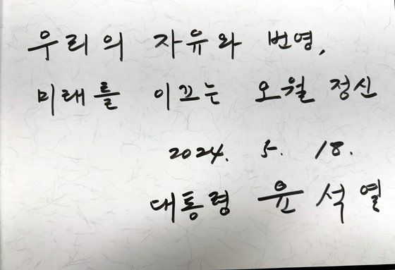 광주시의회 5·18특별위원회 소속 시의원 8명이 18일 오전 광주 북구 국립 5·18민주묘지에서 열린 5·18민주화운동 44주년 기념식 윤석열 대통령의 기념사 도중 '5·18 헌법전문 수록'을 촉구하는 기습 손팻말 시위를 벌이고 있다. 뉴시스