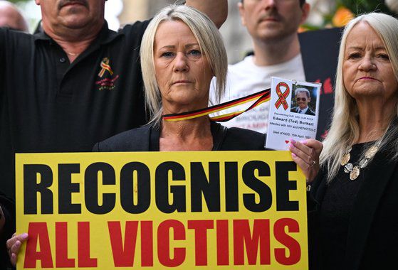 혈액 스캔들 관련 피해자들이 플래카드를 들고 시위하고 있다. AFP=연합뉴스