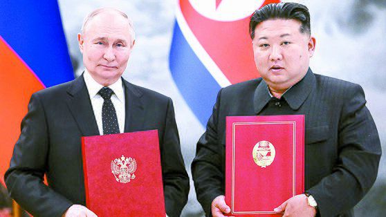 지난 19일 북한 평양에서 열린 북·러 정상회담에서 블라디미르 푸틴 러시아 대통령과 김정은 북한 국무위원장이 체결한 조약을 들어보이는 모습. AP.
