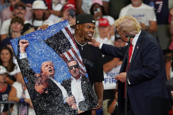 3일(현지시간) 미국 조지아주 애틀랜타에서 도널드 트럼프 전 대통령이 지역 예술가가 그린 암살 미수 사건 관련 작품을 함께 바라보고 있다. 로이터=연합뉴스