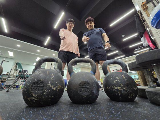 안산 선부중 역도부 조성현(50·왼쪽) 코치와 안산공고 역도부 박상민(32) 코치가 역도 여자 81㎏ 이상급 국가대표 박혜정(21·고양시청)이 월등한 기량을 보여 새로 들였다는 케틀벨을 가리키고 있다. 손성배 기자