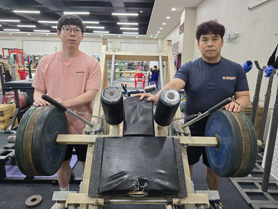 안산 선부중 역도부 조성현(50·왼쪽) 코치와 안산공고 역도부 박상민(32) 코치가 역도 여자 81㎏ 이상급 박혜정 등이 사용했던 선부중 역도부 레그프레스 옆에 나란히 섰다. 손성배 기자