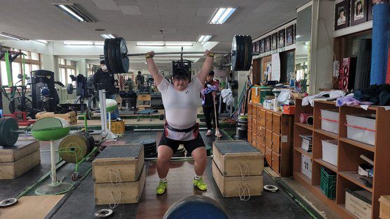 여자 역도 국가대표 박혜정(21)이 지난 2021년 10월 전국체전에서 한국신기록을 수립한 뒤 선부중 역도장으로 돌아와 조성현 선부중 역도부 코치가 지켜보는 가운데 훈련하고 있다. 손성배 기자