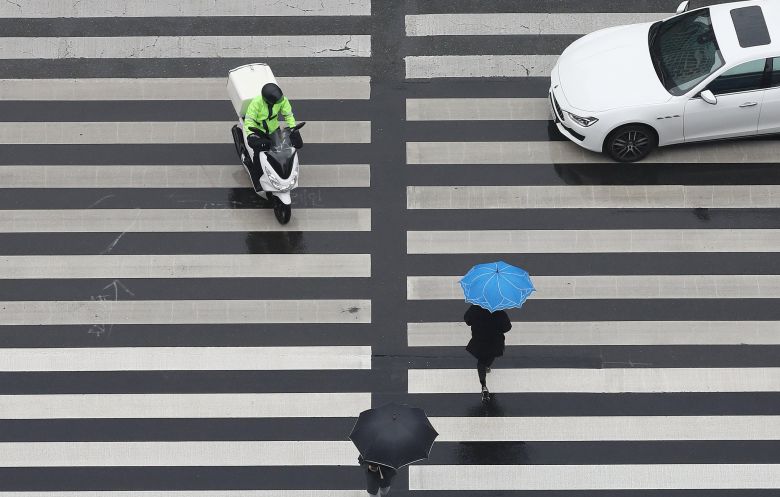 배달오토바이가 보행자 신호로 바뀐 횡단보도를 침범해 시민의 안전을 위협하고 있다. 뉴스1