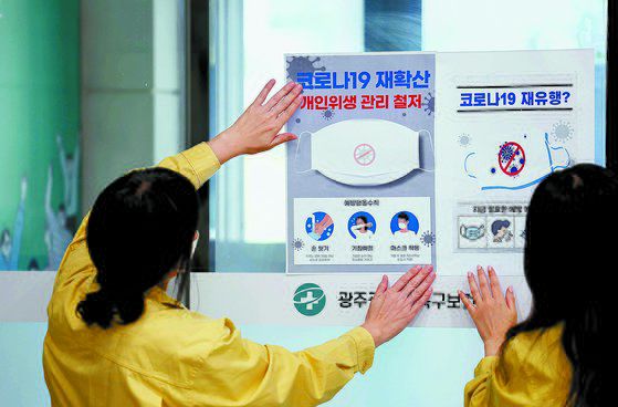 지난 14일 광주 북구보건소에서 감염병관리팀 직원들이 코로나19 확산 예방을 위해 개인위생 수칙이 적힌 홍보물을 부착하고 있다. 연합뉴스