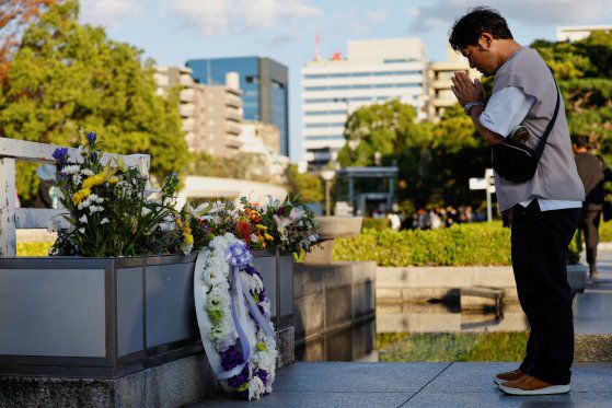 지난 12일 일본 히로시마 평화공원을 찾은 한 방문객이 원폭 희생자 추모를 하고 있다. 로이터=연합뉴스