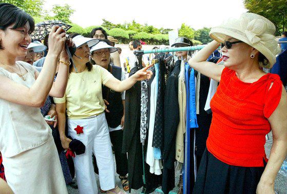 2004년 6월 양재동 서초문화예술공원에서 열린 '아름다운 WeStart 나눔장터'에서 연예인들 기증품을 판매하던 탈랜 김수미(오른쪽)가 한 팬의 사진기 앞에서 포즈를 취하고 있다. 중앙포토