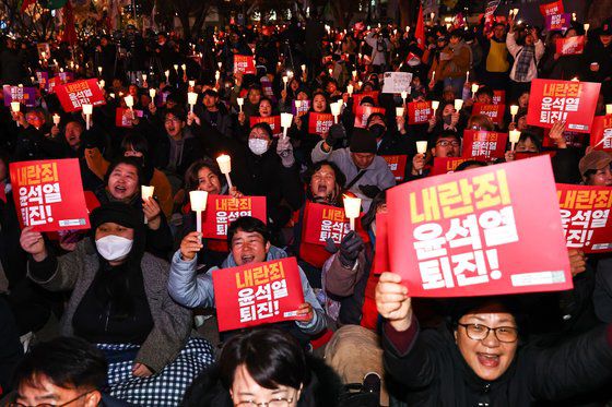 4일 오후 서울 종로구 동화면세점 앞에서 열린 '내란죄 윤석열 퇴진!시민촛불'에서 시민사회단체 참석자들이 촛불집회를 하고 있다. 김종호 기자 20241204