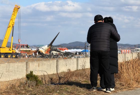 30일 오후 전남 무안군 무안국제공항 제주항공 여객기 참사 현장에서 유가족들이 여객기 잔해를 바라보고 있다. 연합뉴스