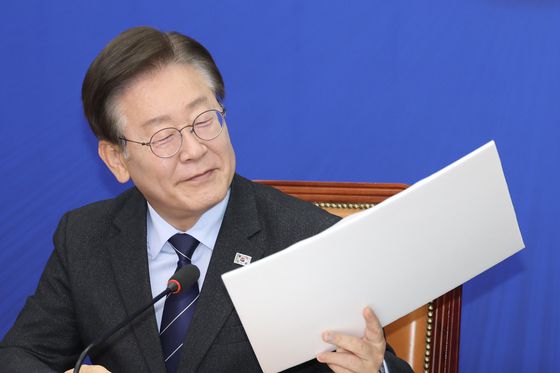 이재명 더불어민주당 대표가 지난해 6월10일 오전 서울 여의도 국회에서 열린 최고위원회의에 참석해 장경태 최고위원이 준비한 김성태 쌍방울 전 회장 전과 내역, 주가조작 의혹 관련 자료를 보고 있다. 전민규 기자