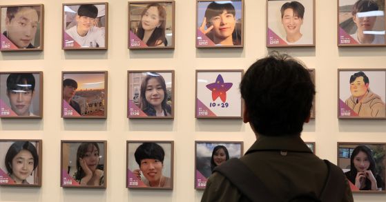 지난해 11월 서울 종로구 적선현대빌딩에 열린 '10·29 이태원 참사 기억·소통공간 이전 '별들의 집' 개소식에서 한 관계자가 희생자들의 사진을 바라보고 있다. 뉴스1