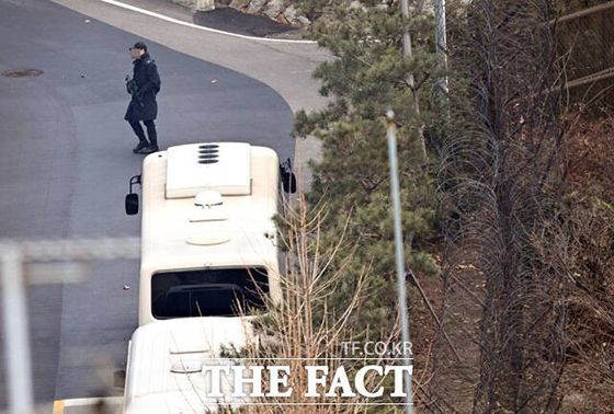 13일 서울 한남동 대통령 관저에서 한 경호처 관계자가 소총을 지닌 채 경내를 이동하고 있다. 사진 더팩트