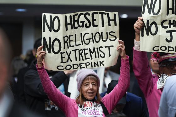 도널드 트럼프 미국 대통령 당선인의 국방장관 지명자인 피트 헤그세스의 상원 군사위원회 인준 청문회가 열린 14일(현지시간) 워싱턴 국회의사당에서 한 시위대가 팻말을 들고 있다. AP=연합뉴스