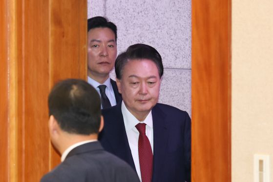 윤석열 대통령이 지난 21일 오후 서울 종로구 헌법재판소에서 열린 탄핵심판 3차 변론에 김성훈 대통령 경호처 차장의 경호를 받으며 출석하고 있다. 뉴스1