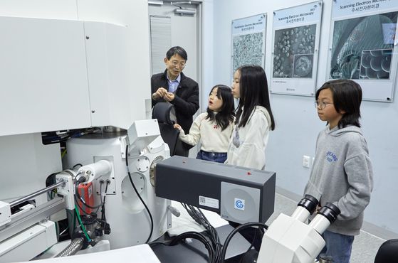 첨단뇌연구장비센터에서 이태관(왼쪽) 센터장과 함께 전자현미경을 둘러보고 있는 소중 학생기자단.