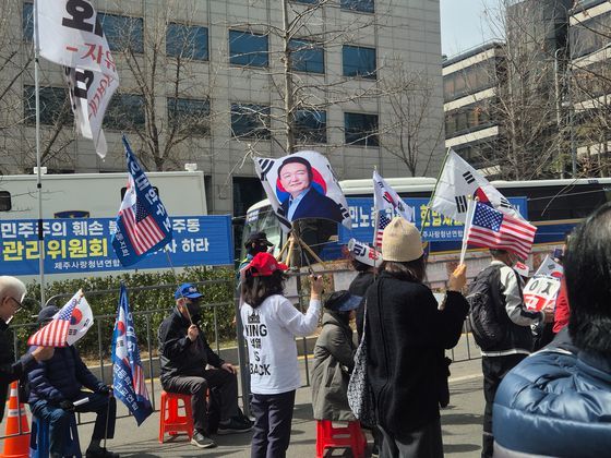 26일 서울 서초동 일대 윤석열 대통령 지지자가 대통령 사진과 태극기를 흔들고 있다. 오소영기자