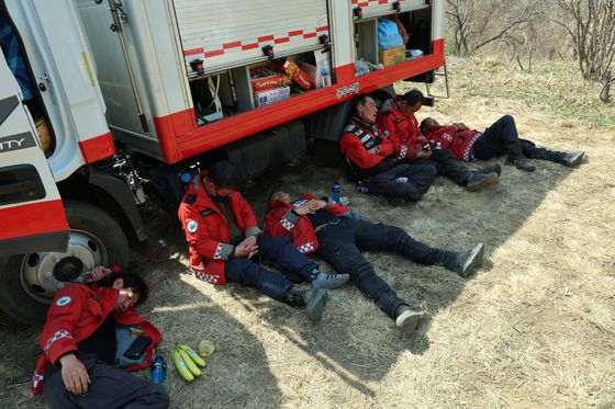 경남 산청·하동 산불 엿새째인 26일 산청군 시천면 동당리 일대에서 산청군 산불진화대원들이 방어선 구축 작업 중 휴식을 취하고 있다. 뉴스1