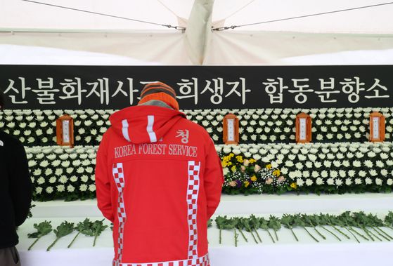 28일 경북 영양군청에 마련된 지역 산불 희생자 6명의 합동분향소를 찾은 산림청 특수진화대원이 헌화하고 있다. [연합뉴스]