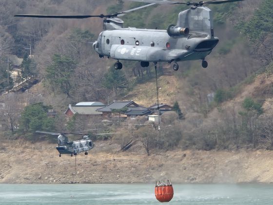 28일 오전 11시30분 경남 산청군 한국수력원자력산청양수발전소 상부댐에서 육군, 공군의 치누크(CH-47) 헬기가 산불 진화 작업을 위해 물을 담고 있다. [사진 독자 제공]