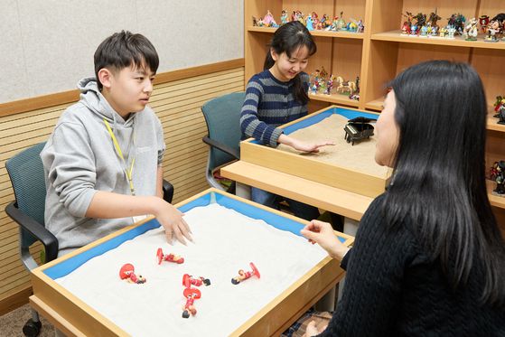 스마트폰 과의존을 고민하는 학생이 좀 더 편하게 고민을 토로하게 돕는 모래 치료 체험을 한 홍원교 (왼쪽)학생기자와 장아원 학생모델.