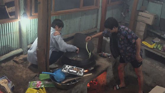 굴뚝이 없어 연기가 자욱한 부엌에서 진과 기안84가 요리하고 있다. 사진 넷플릭스