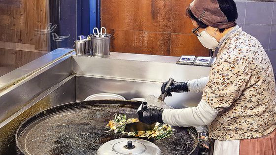 '동래할매파전'에서 파전 부치는 모습. 무쇠 번철 위에서 파전을 부치다가 두껑을 덮어 익힌다.