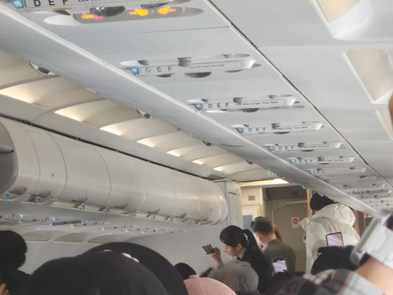 15일 오전 9시쯤 제주공항에서 멈춰선 에어서울 해당항공기 기내에서 승무원이 승객들에게 상황을 설명하고 있다. 독자제공